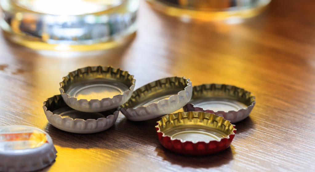 Beer caps and glasses of beer on a pub background